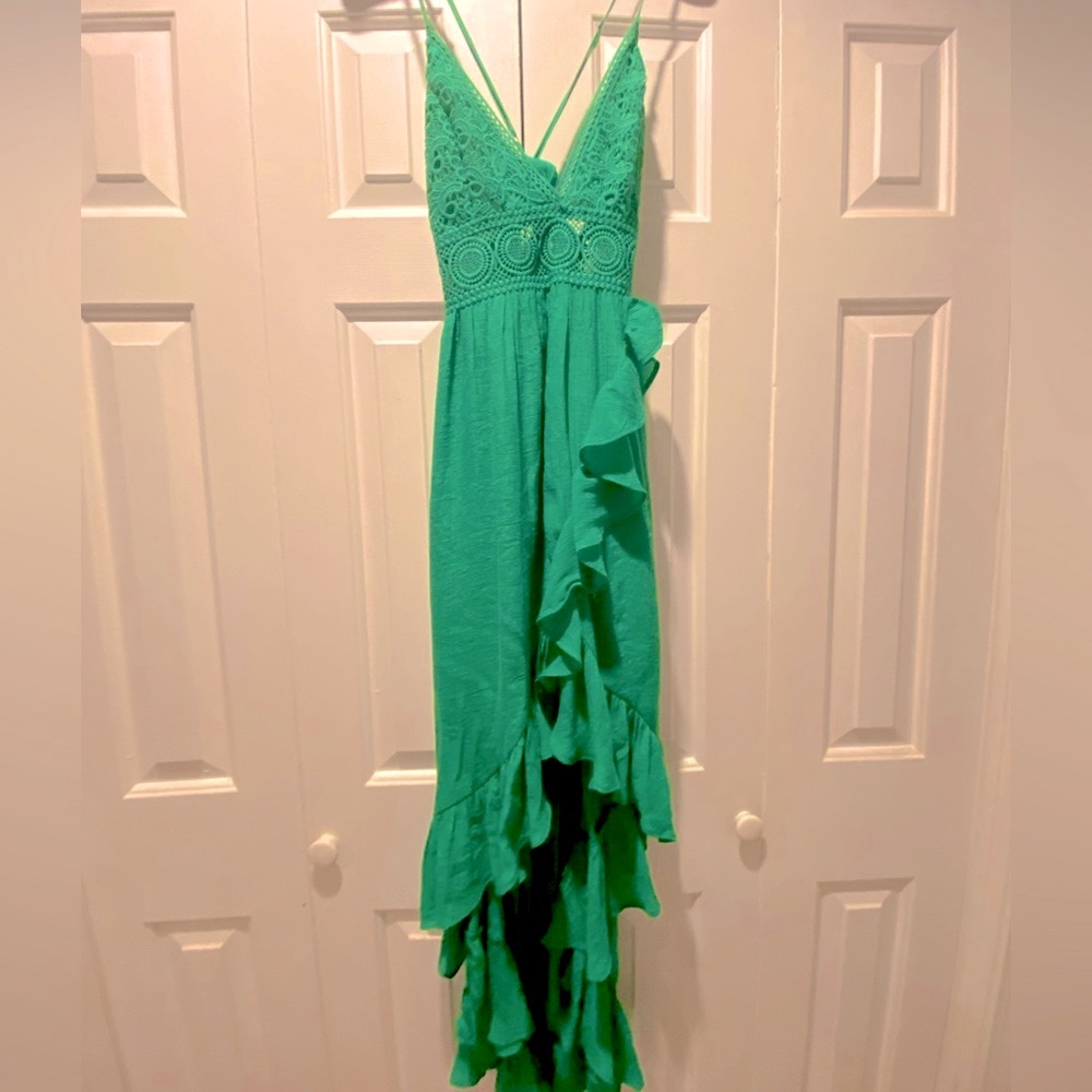 Green ruffle dress with adjustable straps and tie back .